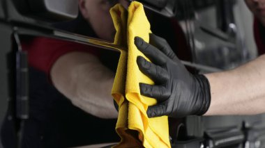 Profesyonel bir erkek (erkek) bir araba seramik ustası bir çekmece, güvenlik gözlükleri ve siyah eldiven bir fiber (sünger) bez kullanarak bir araba seramik koyar.