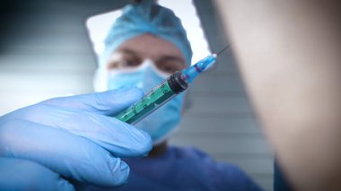 Hastanede, doktor ve doktor asistanı farklı tıbbi araçlar kullanarak tedavi işlemi gerçekleştirmek. Her iki doktor da başlıklarında ve eldivenleriyle cüppeli doktorlar. Kavramı: Diş hekimleri.