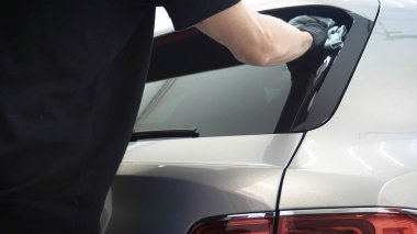 Elinde sprey tabancaları ile çalışan üniforma lı profesyonel ve koruyucu gözlüklü bir solunum cihazı arabanın farklı yerlerine boya (seramik) koyar, elinde bir klasör ile el feneri servis edilebilirlik için bir araba motoru kontrol eder. Kavram 