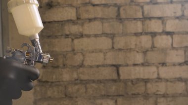 Profesyonel adam (adam) bir garaj (hizmet) bir kazak giymiş çalışma giysileri bir boya tabancası (sprey tabanca) kurar ve boyama başlar (seramik bir tabaka koyarak) bir yat.