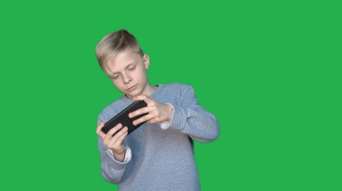 Chromakey arka planda, Genç bir adam (Çocuk) farklı duygular gösterir. Kavramı: yeşil arka plan, Chroma anahtar, gerçek duygular, avcı, like, moda, sarışın.