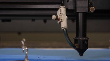 Bir endüstriyel Konfeksiyon fabrikasında, özel bir lazer kesme kumaş belirli Tekstil parçaları keser. Kavramı: lazer makine, haç, bir fabrikada çalışmak, otomatik kesme.