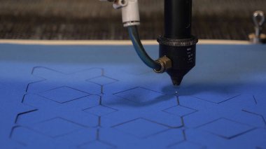 Bir endüstriyel Konfeksiyon fabrikasında, özel bir lazer kesme kumaş belirli Tekstil parçaları keser. Kavramı: lazer makine, haç, bir fabrikada çalışmak, otomatik kesme.