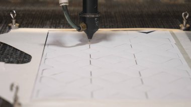 Bir endüstriyel Konfeksiyon fabrikasında, özel bir lazer kesme kumaş belirli Tekstil parçaları keser. Kavramı: lazer makine, haç, bir fabrikada çalışmak, otomatik kesme.