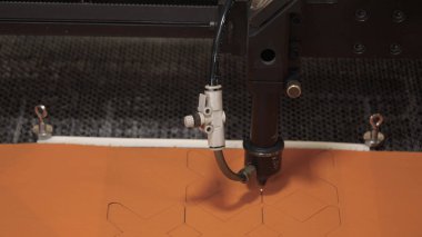 Bir endüstriyel Konfeksiyon fabrikasında, özel bir lazer kesme kumaş belirli Tekstil parçaları keser. Kavramı: lazer makine, haç, bir fabrikada çalışmak, otomatik kesme.