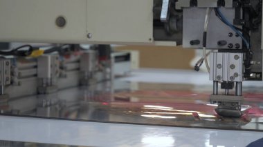 Endüstriyel konfeksiyon fabrikası, özel bir Lazer Kesme Kumaş bazı tekstil parçaları keser. Kavramı: Lazer makinesi, Haçlar, Bir fabrikada çalışma, Otomatik kesim.