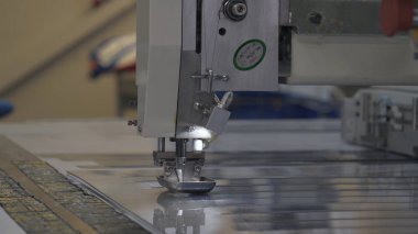 Endüstriyel konfeksiyon fabrikası, özel bir Lazer Kesme Kumaş bazı tekstil parçaları keser. Kavramı: Lazer makinesi, Haçlar, Bir fabrikada çalışma, Otomatik kesim.