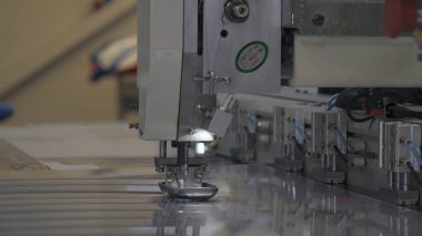 Endüstriyel konfeksiyon fabrikası, özel bir Lazer Kesme Kumaş bazı tekstil parçaları keser. Kavramı: Lazer makinesi, Haçlar, Bir fabrikada çalışma, Otomatik kesim.