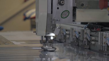 Endüstriyel konfeksiyon fabrikası, özel bir Lazer Kesme Kumaş bazı tekstil parçaları keser. Kavramı: Lazer makinesi, Haçlar, Bir fabrikada çalışma, Otomatik kesim.