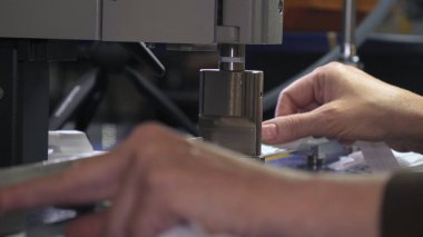 Endüstriyel konfeksiyon fabrikası, özel bir Lazer Kesme Kumaş bazı tekstil parçaları keser. Kavramı: Lazer makinesi, Haçlar, Bir fabrikada çalışma, Otomatik kesim.