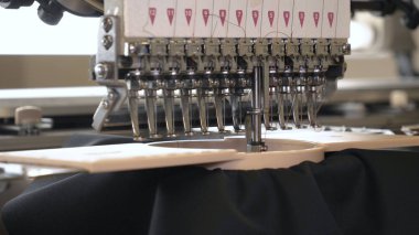 Endüstriyel konfeksiyon fabrikası, özel bir Lazer Kesme Kumaş bazı tekstil parçaları keser. Kavramı: Lazer makinesi, Haçlar, Bir fabrikada çalışma, Otomatik kesim.