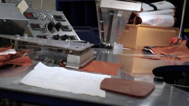 Endüstriyel konfeksiyon fabrikası, özel bir Lazer Kesme Kumaş bazı tekstil parçaları keser. Kavramı: Lazer makinesi, Haçlar, Bir fabrikada çalışma, Otomatik kesim.
