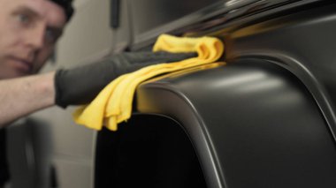 Araba boyama ve seramik iki profesyonel ustalar bir araba deteyling merkezinde, bir mikro fiber ve bez kullanarak seramik bir tabaka bindirme. Konsept: Servis, Yeni araba, Yenile.