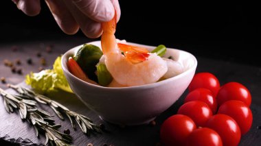 Evde pişirilen yemek (restoranda) aşçı bitmiş makarna tabağını rendelenmiş parmesan peyniri ile mutfak rendesinde süslüyor ve sos ekliyor. Peynir, muhteşem yemek, ağır çekim kavramı.