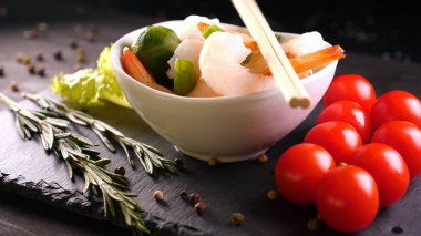 Evde pişirilen yemek (restoranda) aşçı bitmiş makarna tabağını rendelenmiş parmesan peyniri ile mutfak rendesinde süslüyor ve sos ekliyor. Peynir, muhteşem yemek, ağır çekim kavramı.