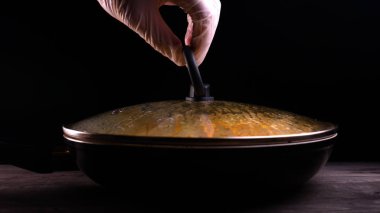 Evde pişmiş yemek (bir restoranda) şef açar (kaldırır) tavadan kapağı. Onu makarna (erişte) farklı renkli görülebilir, şef bir mutfak rendesi üzerinde rendelenmiş Parmesan peyniri ile bitmiş makarna çanak süsler ve sos ekleyerek