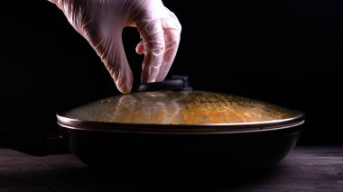 Evde pişmiş yemek (bir restoranda) şef açar (kaldırır) tavadan kapağı. Onu makarna (erişte) farklı renkli görülebilir, şef bir mutfak rendesi üzerinde rendelenmiş Parmesan peyniri ile bitmiş makarna çanak süsler ve sos ekleyerek