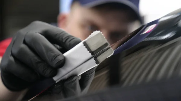 Profesyonel bir erkek (erkek) bir araba seramik ustası bir çekmece, güvenlik gözlükleri ve siyah eldiven bir fiber (sünger) bez kullanarak bir araba seramik koyar.