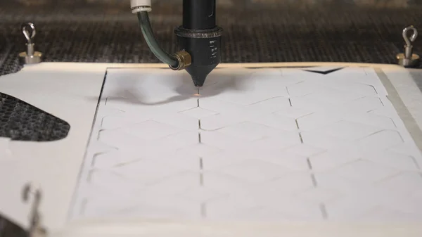 In an industrial garment factory, a special Laser Cutting Fabric cuts out certain textile pieces. Concept of: Laser machine, Crosses, Work in a factory, Automatic cutting.