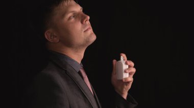 Bir takım elbise li genç yakışıklı adam (adam) siyah bir arka plan önünde bakar. Konsept: Adam, Genç, Düşün, Bak, Takım.