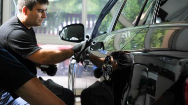 İki uzman arabayı nemden, araba yıkamadan kurutur. Konsept: Kurutma Makineleri, Profesyoneller, Oto Servisi.