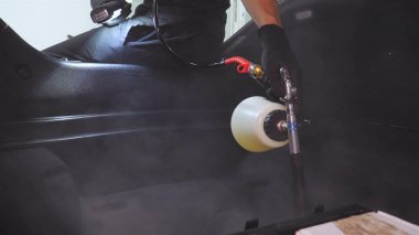 Yakışıklı genç adam, (adam) arabada profesyonel kuru temizleme salonu yapıyor. Konsept: Oto Oto Servisi, Oto Yıkama, Kuru Temizleme Makineleri.