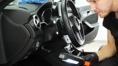 Yakışıklı genç adam, (adam) arabada profesyonel kuru temizleme salonu yapıyor. Konsept: Oto Oto Servisi, Oto Yıkama, Kuru Temizleme Makineleri.