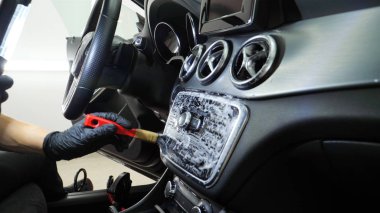 Yakışıklı genç adam, (adam) arabada profesyonel kuru temizleme salonu yapıyor. Konsept: Oto Oto Servisi, Oto Yıkama, Kuru Temizleme Makineleri.