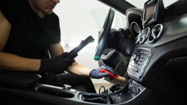 Yakışıklı genç adam, (adam) arabada profesyonel kuru temizleme salonu yapıyor. Konsept: Oto Oto Servisi, Oto Yıkama, Kuru Temizleme Makineleri.