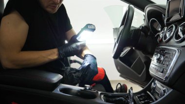 Yakışıklı genç adam, (adam) arabada profesyonel kuru temizleme salonu yapıyor. Konsept: Oto Oto Servisi, Oto Yıkama, Kuru Temizleme Makineleri.