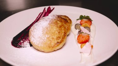 Bir restoranda genç yakışıklı bir adam (adam) reçel ile krep yemek bir takım elbise oturur. Kavramı: İyi ruh hali, Lezzetli gıda, Krep, Kahve, Çay, İş adamı, Kahvaltı, Çilek, Lifestyle.