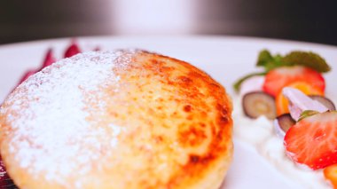 Bir restoranda genç yakışıklı bir adam (adam) reçel ile krep yemek bir takım elbise oturur. Kavramı: İyi ruh hali, Lezzetli gıda, Krep, Kahve, Çay, İş adamı, Kahvaltı, Çilek, Lifestyle.