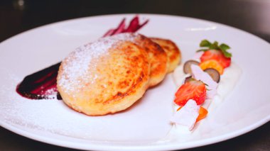 Bir restoranda genç yakışıklı bir adam (adam) reçel ile krep yemek bir takım elbise oturur. Kavramı: İyi ruh hali, Lezzetli gıda, Krep, Kahve, Çay, İş adamı, Kahvaltı, Çilek, Lifestyle.