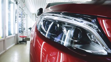 Profesyonel bir kaporta ve far cilası işçisi arabayı boyamadan veya satışa hazırlandıktan sonra taşır. Taze arabalar, Otomotiv Merkezi, Hizmet, Profesyonel.