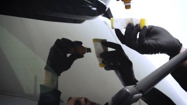 Profesyonel bir işçi olarak yakından gösterilen bir parlatma aracı (makine) kullanarak taşıma (araba) gövdesi parlatır. Konsept: Oto servisi, Araba Boyama, Makine yıkama.