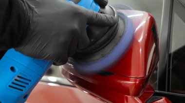 Profesyonel bir işçi olarak yakından gösterilen bir parlatma aracı (makine) kullanarak taşıma (araba) gövdesi parlatır. Konsept: Oto servisi, Araba Boyama, Makine yıkama.