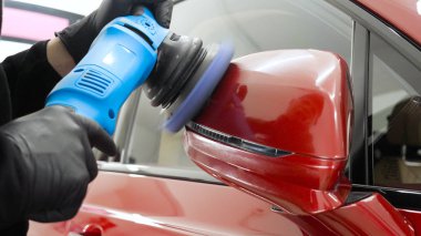 Profesyonel bir işçi olarak yakından gösterilen bir parlatma aracı (makine) kullanarak taşıma (araba) gövdesi parlatır. Konsept: Oto servisi, Araba Boyama, Makine yıkama.