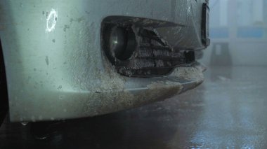 Profesyonel adam (adam) bir araba yıkama Karcher kullanarak çok kirli bir araba yıkar ve köpük sıçramaları, bir sünger ile araba siler. Konsept: Oto yıkama, yıkama aksesuarları, yüksek basınç altında.