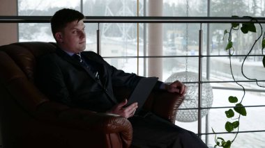 Bir adam pencerenin yanında binada elinde bir cep telefonu tutar,İki genç erkek (çocuklar), işadamları, el sıkışma, bir binada bir toplantıda birbirlerine selamlama (ofis) Kavramı: İş toplantısı, Çok Yakın, Önemli Meet