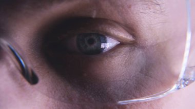 Bir erkek laboratuvar teknisyeni (profesyonel), laboratuvar gözlük bir bilim işçisi, bir test tüpü bakar ve çok dikkatli kan damlar, Erkek doktor gözlük gözlük ile eldiven giyen iş üniforması in vitro analizi inceler. Kavramı: Proffessional d