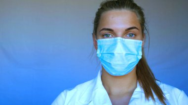 Genç güzel bir kadın, hemşire, doktor, auscultation, küçük çocuk, hasta, mavi lastik eldivenler, steteskop, beyaz mavi arka plan. Güzel yeşil gözler, genç kadın..