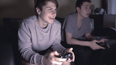 İki arkadaş (çocuklar) video oyun konsolu oynamak, eğlenmek, gülmek, joystick tutun.