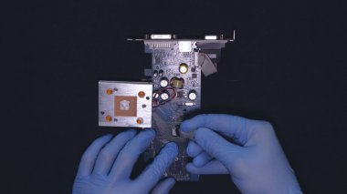 Master mavi lastik eldiven, tahta tamir, çip, ekran kartı temizleme, bir nokta lehim, siyah arka plan.