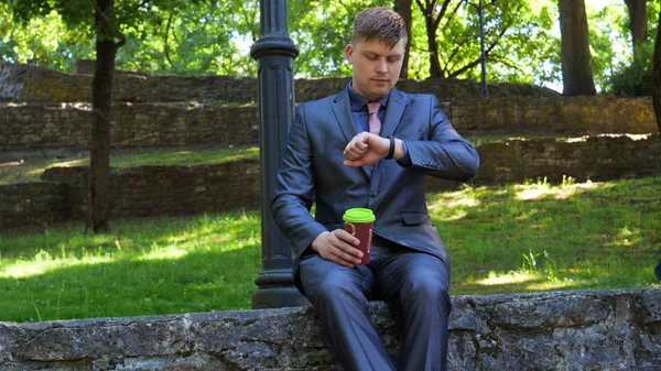 Young handsome guy businessman in a suit, (man) climbs the stairs with a black bag in his hands. Concept: business, suit, guy, man, bag, businessman.