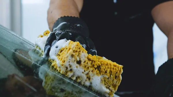 Profesyonel araba yıkama hizmeti sonra profesyonel araba yıkayarak mendil ve kurur pencere. Konsept: Okuma gözlükleri, Profesyonel çalışma, Siyah eldiven, Mavi bez