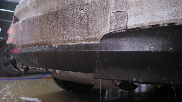 洗車中のプロの男 ケルヒャーを使用して非常に汚れた車を洗い 泡を飛び散らし スポンジで車を拭きます コンセプト 洗面器 高圧下 — ストック写真