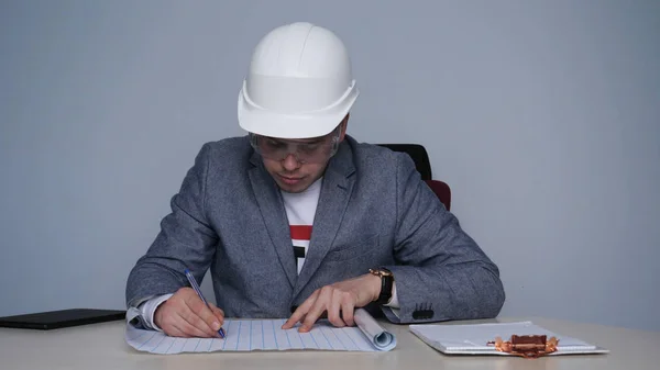 Joven Hombre Arquitecto Con Casco Gafas Protectoras Hace Comprobación Dibujos — Foto de Stock