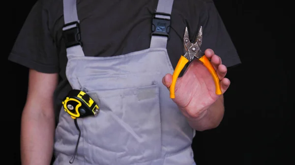 建造者或修理工手里拿着一个卡钳 穿着一件特别的西装 一个黄色的测量指标的磁带 一个黑色的背景 — 图库照片