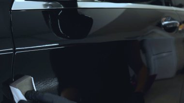 Genç bir profesyonel işçi kırmızı seramik lambalar kurar, bir araba atölyesi, araba yıkama.