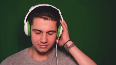 Bir kromatinin arka planı, genç bir adam (çocuk) farklı duygular gösterir. Konsept: Yeşil arka plan, Chroma Key, Gerçek duygular, Fighter, Like, Fashion, Blonde.